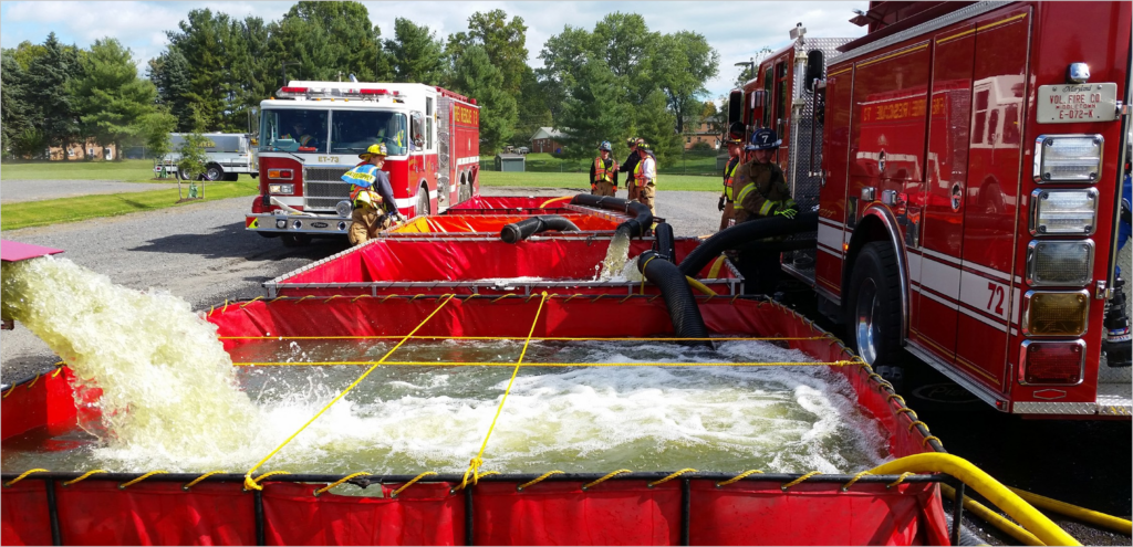 Firefighters using an original Fol-Da-Tank folding portable water tank