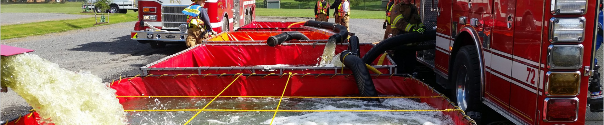 Firefighters using an original Fol-Da-Tank folding portable water tank